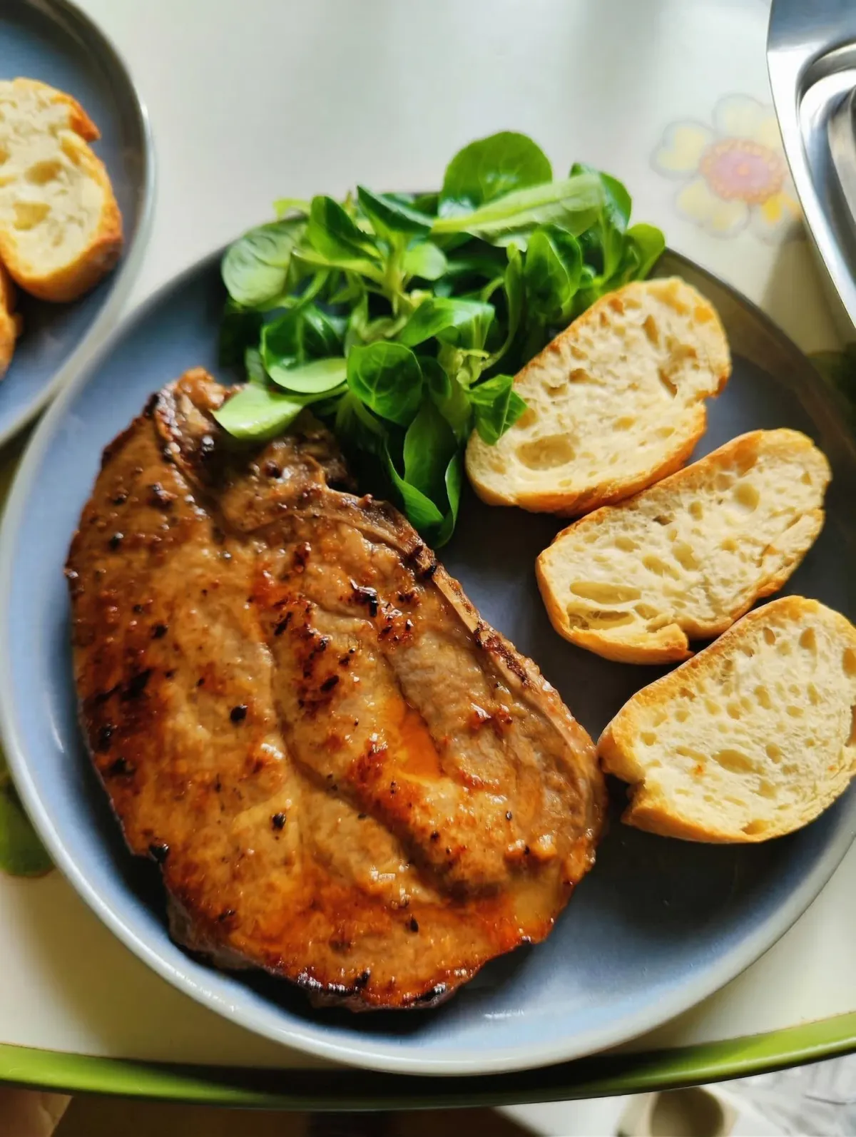 牛排、烤面包与绿色沙拉组成的家常餐食